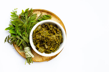 Senna siamea boiled leaves in bamboo basket on white