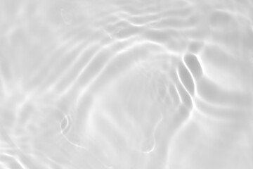 Closeup of desaturated transparent clear calm water surface texture with splashes and bubbles. Trendy abstract nature background. White-grey water waves in sunlight.