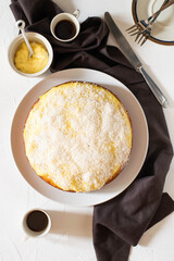Sponge cake with cream on top and coconut flour. White background