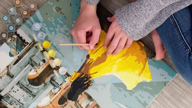4k Female hands coloring draw canvas Picture by numbers girl Triumphal Arch Paris. Creative hobby. Painting for beginners. Leisure activity for stay home isolation, anti-stress idea. Meditation, relax