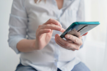 hands holding smartphone with glowing screen girl looking for information in a smartphone phone delicate background delicate background