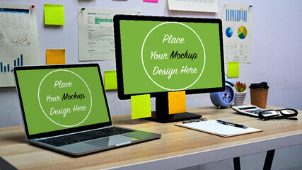 Blank screen mockup psd computer and laptop with office equipment on the desk in the office.