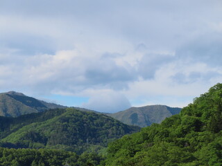 Fototapeta na wymiar 新緑の山と青空と雲