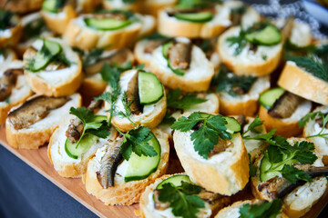 Sandwiches with sprats, fresh cucumber and parsley. Close-up, selective focus
