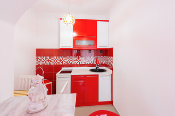 Red white kitchen interior in hotel apartment