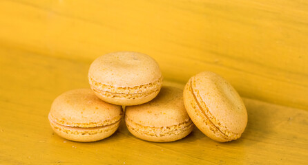 French yellow macaroons on a yellow background, concept yellow on yellow