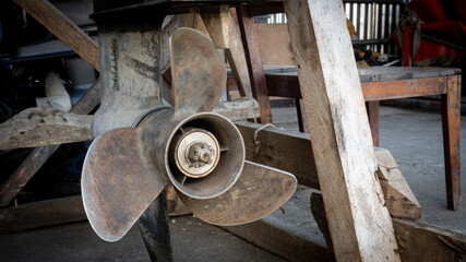 Old boat propeller at a marine workshop