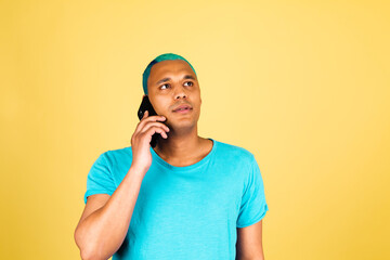 Black african man in casual on yellow background with mobile phone positive and confident listen talk having conversation