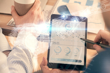 Double exposure of man's hand holding and using a digital device and brain hologram drawing. Data...
