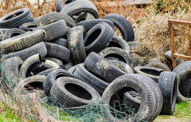Fototapeta na wymiar Novi Sad, Serbia - December 21. 2020: Waste tire recycling in Novi Sad. A pile of damaged, old, discarded, car tires for recycling