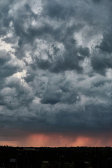 A rain storm at sunset causes reddish colors behind the curtain of water in Madrid. Spain