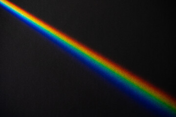 Rainbow streek on black textured paper background