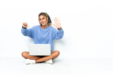 Young blonde Uruguayan girl with the laptop isolated on white background counting six with fingers
