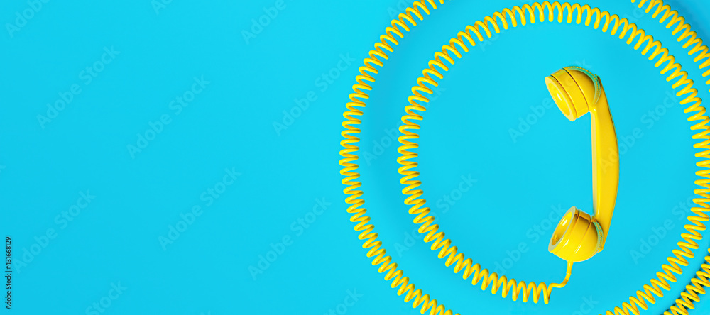 Wall mural old fashioned yellow telephone handset with coiled cord and space for text. communications concept