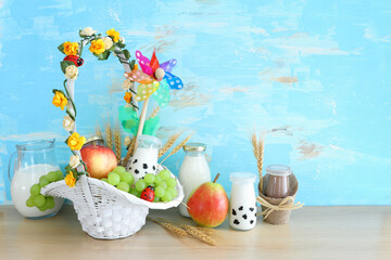 Photo of dairy products over wooden table. Symbols of jewish holiday - Shavuot