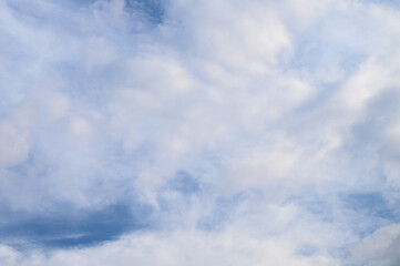 Abstract background of white fluffy clouds on a bright blue sky