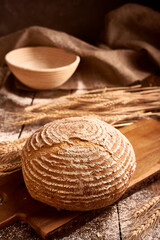 Fototapeta na wymiar bread with wheat on a wooden board
