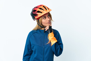 Young blonde Uruguayan cyclist woman isolated on background looking up while smiling