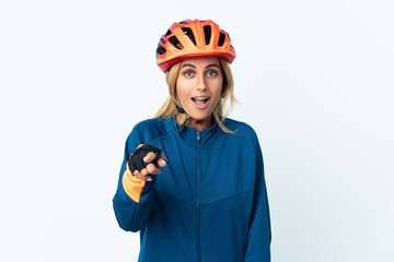 Young blonde Uruguayan cyclist woman isolated on background surprised and pointing front