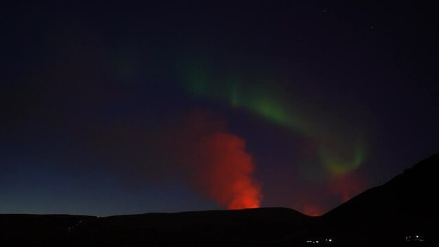 Epic night shot of erupting volcano and Aurora Borealis Lights at dark sky. Geldingadalir,Fagradalsfjall,Iceland.