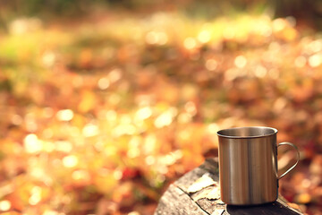 iron mug with hot tea on a camping trip active lifestyle autumn yellow park