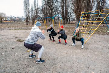 Group fitness workout classes outdoors. Socially Distant Outdoor Workout Classes in public parks. Three women and man training together in the public park. Health, wellness and community concept
