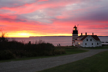 Sunrise accents the red and white striped West Quoddy Head Lighthouse in Lubec Maine.