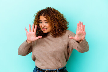 Young latin curvy woman isolated on blue background rejecting someone showing a gesture of disgust.