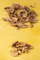 Close-up of peeled walnuts. Walnut shells in the background