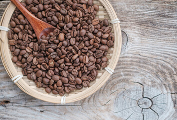 coffee beans in a bamboo plate on the background of an old board