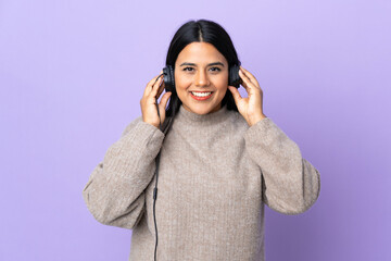Young latin woman woman isolated on purple background listening music
