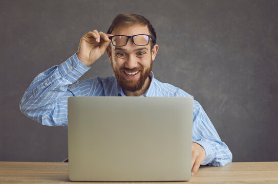 Funny Excited Surprised Man Takes Off Glasses Looking At Screen Of Laptop Computer Device. Happy Lucky Guy Gets Job Offer Business Email, Wins A Cool Prize Or Earns Easy Money On Gaming Website