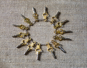 A bunch of keys for pocket watches on canvas.