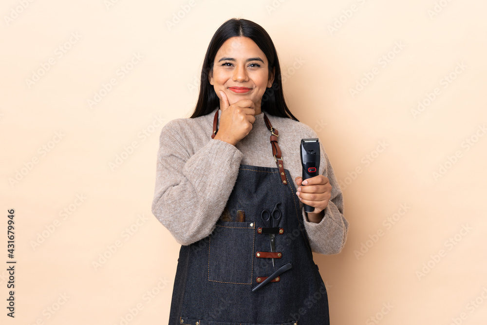 Wall mural young colombian woman hairdresser isolated on beige background laughing