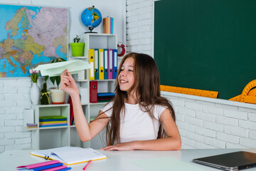 lets fly. childhood development. get knowledge through study. kid in classroom with chalkboard. child hold paper plane. back to school. formal education in modern life. home schooling concept