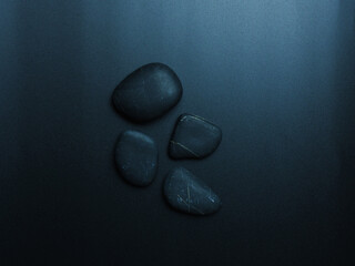 Black smooth stones on dark background.