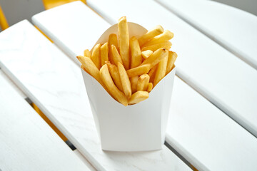 French fries in a white delivery box on a white background. American fast food. Food delivery