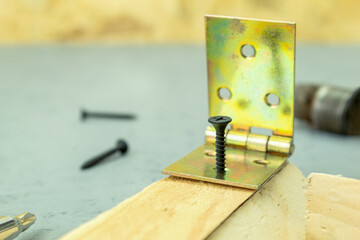 The door hinges are fastened with a self-tapping screw and a screwdriver