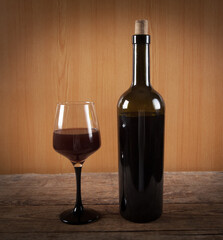 Bottle, glass and  wine on wooden background.