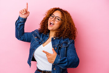 Young latin curvy woman isolated on pink background dancing and having fun. - obrazy, fototapety, plakaty
