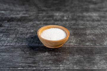 Fototapeta na wymiar salt in a wooden bowl on a gray table