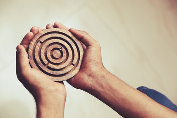 Indian boy paying wooden Labyrinth Maze Toy Game 