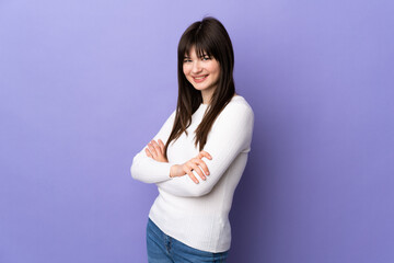 Young Ukrainian woman isolated on purple background with arms crossed and looking forward