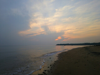 Quiet beach under a cloudy sky at dusk