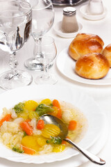 Plate with fresh hot soup on the table and homemade buns