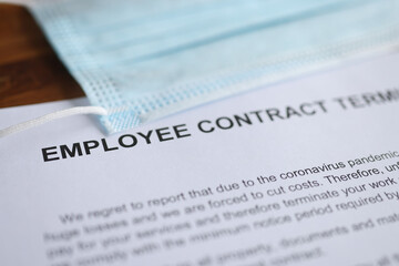 Termination of employment contract due to coronavirus pandemic, along with protective mask lies on...