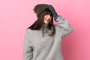 Teenager Ukrainian girl with winter hat isolated on white background laughing
