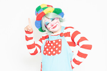 白背景の前でポイントを示すピエロ