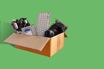 Hard disks and motherboards and old computer hardware accessories, Electronic waste in paper boxes isolated on green background, Reuse and Recycle concept.