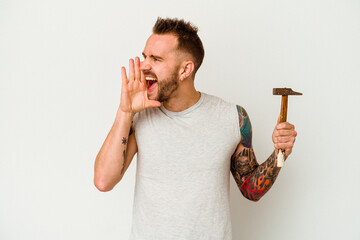 Young tattooed caucasian man isolated on white background shouting and holding palm near opened mouth.